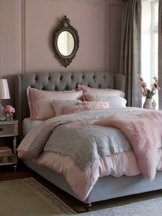 a bedroom with pink and gray bedding, pillows and rugs on the floor