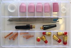 an assortment of tools in a plastic box with pink and gold items inside it,