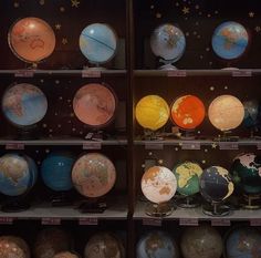 a display case filled with lots of different colored globes and stars on the wall