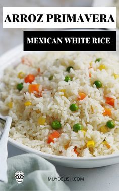 mexican rice with peas and carrots in a white bowl on top of a table