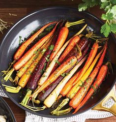 carrots and other vegetables are cooking in a pan