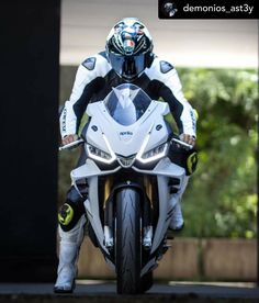 a man riding on the back of a white motorcycle