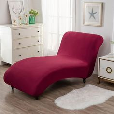 a red chaise lounge chair in a white room