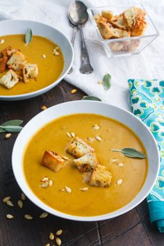 two white bowls filled with soup and croutons