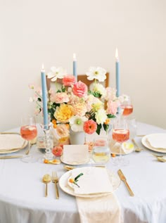 the table is set with flowers and candles