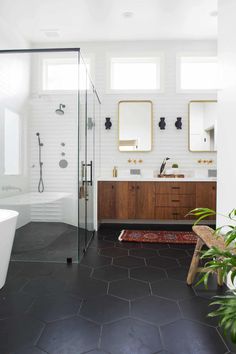 a bathroom with two sinks, a shower and a rug on the floor in front of it