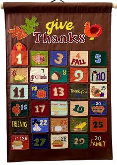 a quilted wall hanging with the words give thanks written in different colors and numbers