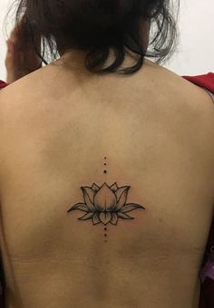 a woman's back with a lotus tattoo on it