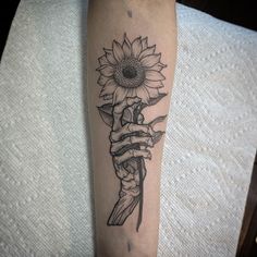 a tattoo on the arm of a woman with a sunflower