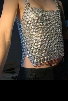 a close up of a person wearing a top with chains attached to the chest and back