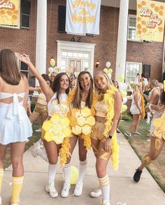 three girls dressed in cheerleader outfits posing for the camera