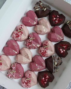 a box filled with lots of different types of heart shaped chocolates on top of each other