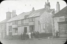 an old black and white photo of people standing in front of a building