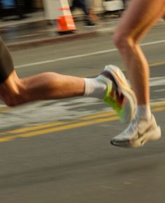 two people running down the street with their feet in the air and one person wearing white socks