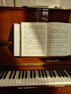 an open book sitting on top of a piano