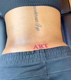 a woman's stomach with the word art tattooed on her lower back and bottom