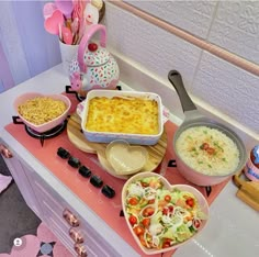 an assortment of food is displayed on a counter top with utensils and bowls