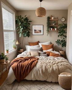 a bed with blankets, pillows and plants in a room that looks like it has been decorated