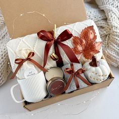 a gift box filled with coffee, cookies and other holiday treats sitting on a table