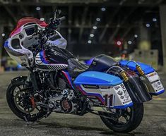 a blue and red motorcycle parked in a parking lot next to a building at night