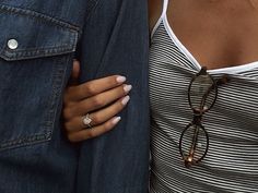 a woman with her hand on the back of another woman's shoulder, both wearing glasses