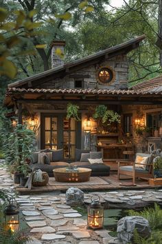 an outdoor living area is lit up with candles and lights on the patio, along with stone walkways