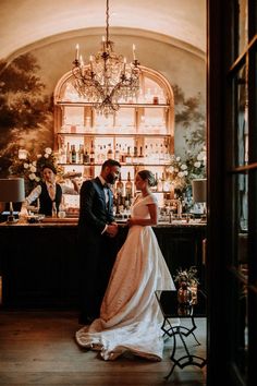 a bride and groom standing in front of a bar