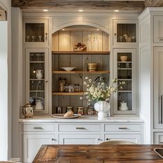 a large kitchen with white cabinets and wooden counter tops, along with an island in the middle