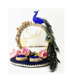 a peacock sitting on top of a table next to some cupcakes and flowers