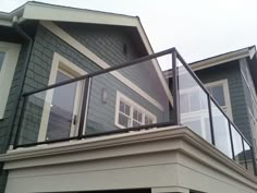 a house with a balcony that has glass railings on it