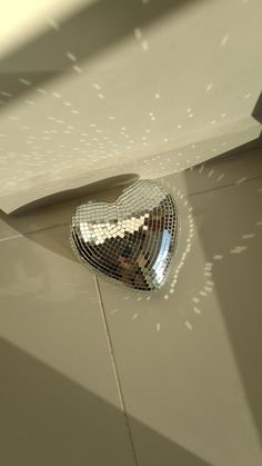 a shiny heart shaped mirror on the floor