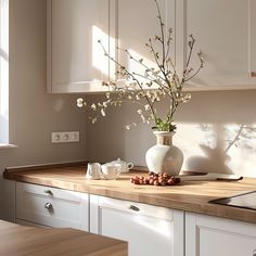 a vase filled with flowers sitting on top of a wooden counter