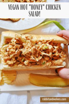 a person holding a sandwich in front of some crackers