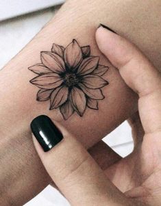 a woman's arm with a flower tattoo on the left side of her wrist