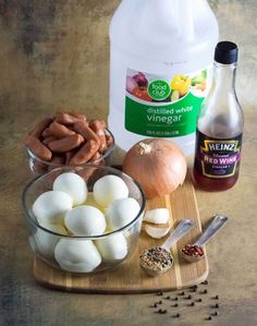 ingredients to make an egg salad on a wooden cutting board with onions, garlic and mustard