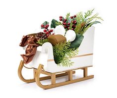 a wooden sleigh filled with flowers and greenery