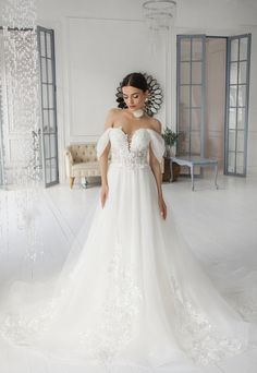 a woman in a white wedding dress posing for the camera with her hands on her hips