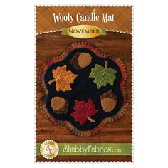 the woolly candle mat is designed with leaves and acorns on black fabric