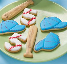 decorated cookies are arranged on a plate with baseball bats and mitts in the middle