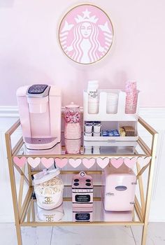 a pink and gold starbucks coffee station with various items on it