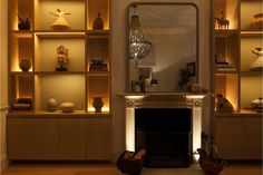 a living room filled with lots of furniture next to a fire place in front of a mirror