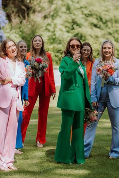 6 bridesmaids playing outdoor garden games in colourful suits. Pink, blue, red, green, orange and light blue Non Formal Wedding Attire, Bridal Party In Suits, Bridesmaid In Suits, Pant Suit Bridal Party, Bridesmaid In Suit, Fun Wedding Outfits, Colorful Fun Wedding, Wedding Guest Dress Colorful, Multi Coloured Bridesmaids