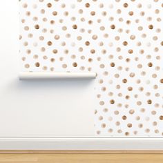 a white wall with brown spots on it and a wooden floor in front of it