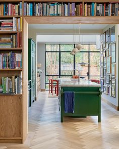 an open kitchen and living room with lots of books on the shelves in front of it