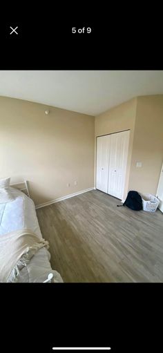 an empty room with a bed, closet and other items on the floor in it