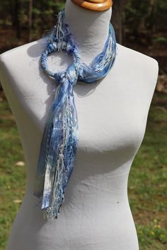 a white mannequin wearing a blue scarf