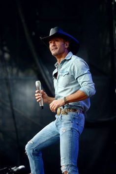 a man with a cowboy hat holding a microphone