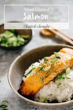 salmon on rice in a bowl with chopsticks and garnished with scallions