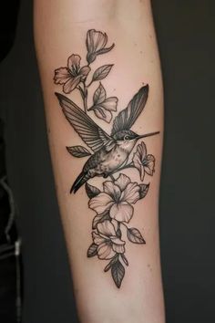 a bird sitting on top of a branch with flowers