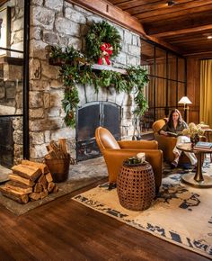 a living room filled with furniture and a fire place next to a fireplace covered in greenery